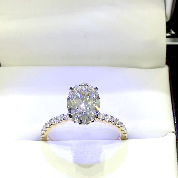 18kt Yellow Gold Engagement Ring with 2.1 carat lab diamond at the center (Color: D | Clarity: VVS2 | Oval Cut) and natural E / VVS grade Setting Diamonds. Hidden Halo setting and collar on the neck with 75% diamonds on the shank.
